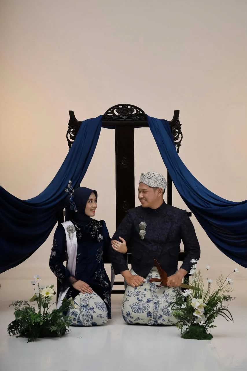 Dewi dan Nuriel dalam busana adat bernuansa biru navy
