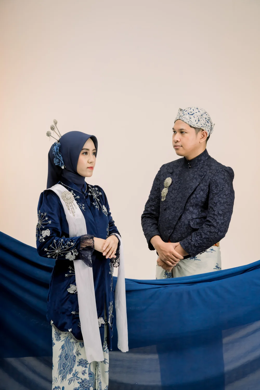 Dewi dan Nuriel saling berhadapan dengan kain biru di depan mereka